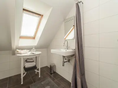 a bathroom with a sink and a mirror at Peaceful Dune Retreat with Garden in Schoorl