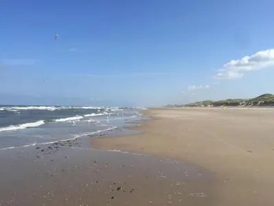 a beach with the ocean and the shoreline at Peaceful Dune Retreat with Garden in Schoorl