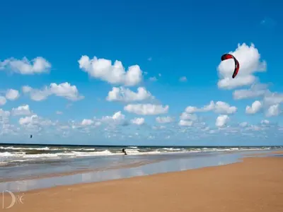 a person is flying a kite on the beach at Holiday Home Egmond near Beach in Egmond aan Zee