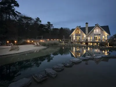 a large house with a pond in front of it at Holiday Home with bubble bath in Noordwijk in Noordwijk