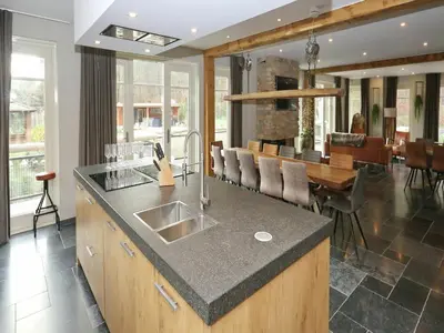 a kitchen with a sink and a dining room at Holiday Home with bubble bath in Noordwijk in Noordwijk