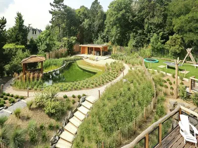 a garden with a pathway and a pond at Holiday Home with bubble bath in Noordwijk in Noordwijk