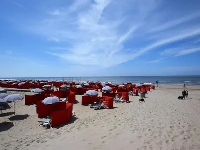 a group of chairs and umbrellas on a beach at Holiday Home with bubble bath in Noordwijk in Noordwijk