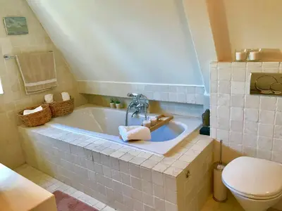 a bathroom with a bath tub and a toilet at Charming countryhouse near Amsterdam in Abcoude