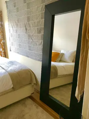 a mirror in a room next to a bed at Charming countryhouse near Amsterdam in Abcoude