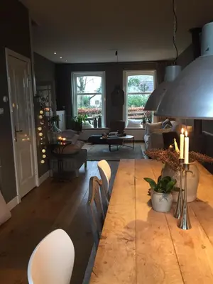 a living room with a large wooden table and chairs at Charming countryhouse near Amsterdam in Abcoude