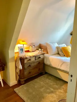 a bedroom with a bed and a dresser with a lamp at Charming countryhouse near Amsterdam in Abcoude