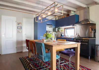 a kitchen with a wooden table and blue cabinets at Kitty's Place Warmond in Warmond