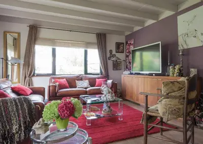 a living room with a couch and a tv at Kitty's Place Warmond in Warmond