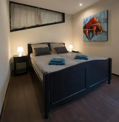 a bedroom with a bed with two blue pillows on it at Ghoyhuys in Leiderdorp