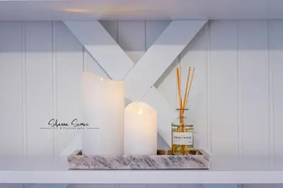 a shelf with two candles and a bottle of oil at Carpe Diem Egmond aan Zee by Urban Home Stay in Egmond aan Zee