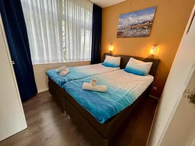 a bedroom with a bed with two towels on it at Reumann Holiday Apartments De Schelp 5 in Zandvoort