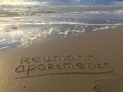 a sign written in the sand on the beach at Reumann Holiday Apartments De Schelp 5 in Zandvoort