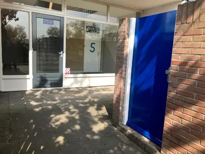 a blue door in front of a brick building at Reumann Holiday Apartments De Schelp 5 in Zandvoort