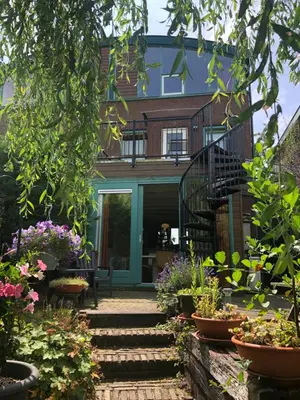a house with a garden with flowers and stairs at Luxe Room Canal Sight in Amsterdam