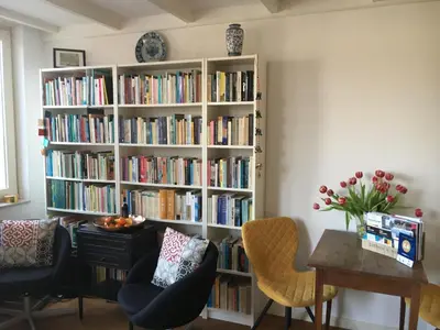 a book shelf filled with books in a living room at Luxe Room Canal Sight in Amsterdam