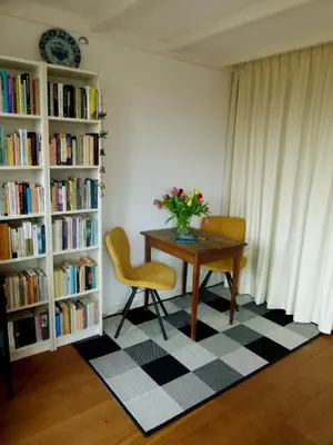 a table and chairs in a room with bookshelves at Luxe Room Canal Sight in Amsterdam