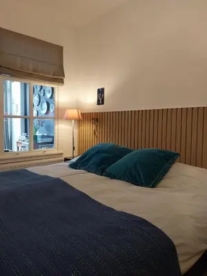 a bedroom with a large bed with a window at B&B Noordwijk Binnen in Noordwijk