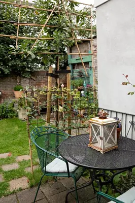 a table with a lantern on top of it in a garden at B&B Noordwijk Binnen in Noordwijk