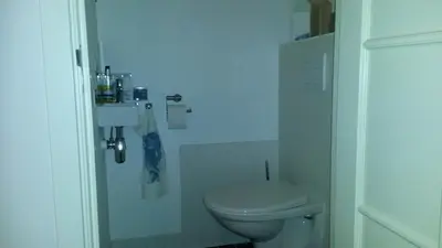 a white bathroom with a toilet and a sink at B&B Noordwijk Binnen in Noordwijk