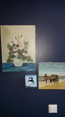 two pictures of a vase of flowers and a painting at B&B Noordwijk Binnen in Noordwijk