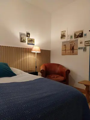 a bedroom with a bed and a chair and a lamp at B&B Noordwijk Binnen in Noordwijk