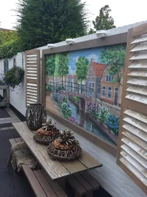 a mural on a wall with some baskets on a bench at B&B 'De Bedstee' in Rijnsburg