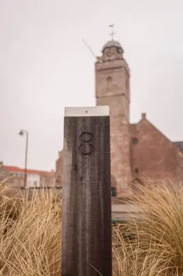 a pole in front of a building with a clock tower at B&B 'De Bedstee' in Rijnsburg