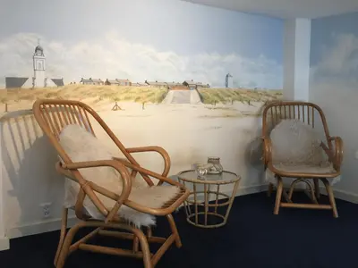 two chairs and a table in a room with a mural at B&B 'De Bedstee' in Rijnsburg