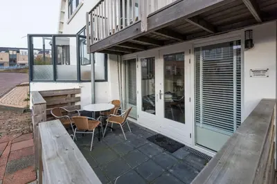 a balcony with a table and chairs on a patio at SummerTime Bergen aan Zee in Bergen aan Zee