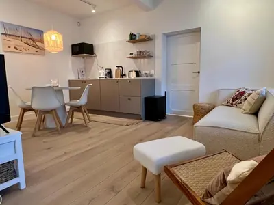 a living room with a couch and a table at SummerTime Bergen aan Zee in Bergen aan Zee