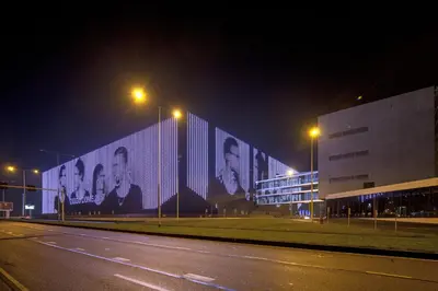a building with a group of faces on it at night at easyHotel Amsterdam Arena Boulevard in Amsterdam