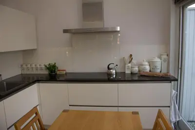 a kitchen with white cabinets and a counter top at Marbles Inn in Amsterdam
