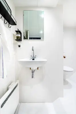 a white bathroom with a sink and a mirror at Asile Flottant in Amsterdam