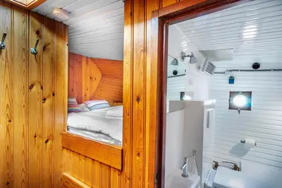 a small room with a bed and a bathroom at Asile Flottant in Amsterdam