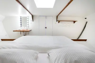 a bedroom with two white beds and a window at Asile Flottant in Amsterdam