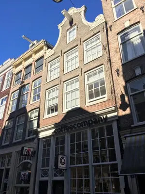 a tall brick building with a store front at Nine Streets Inn in Amsterdam