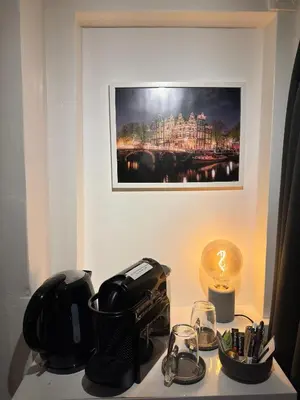 a table with a tea pot and glasses and a painting at Nine Streets Inn in Amsterdam