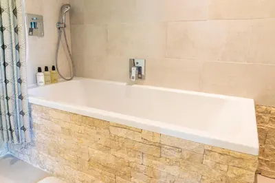 a white bath tub in a bathroom with a shower at Former Rembrandt workshop two bedroom B&B in Amsterdam