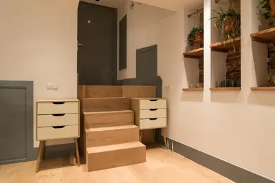 a room with a staircase with wooden drawers and shelves at Saint Claire Studio in Amsterdam