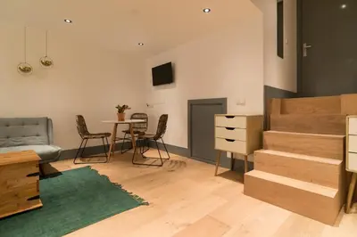 a bedroom with a bed and a table with chairs at Saint Claire Studio in Amsterdam
