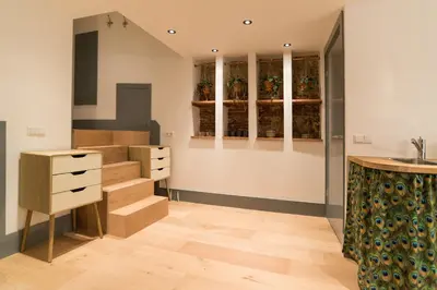 a kitchen with stairs and cabinets and a sink at Saint Claire Studio in Amsterdam