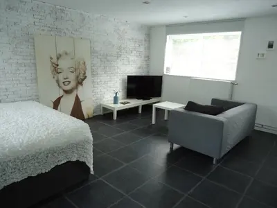 a bedroom with a bed and a chair and a television at B&B Sloterpark in Amsterdam