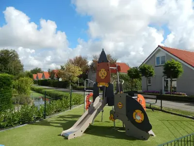 a playground with a slide in a yard at Holiday Home Alk 6 by Interhome in Noordwijk