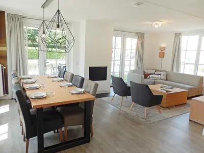 a dining room and living room with a table and chairs at Holiday Home Alk 8-1 by Interhome in Noordwijkerhout