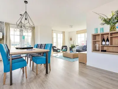 a dining room and living room with a table and chairs at Holiday Home Tapuit 6-2 by Interhome in Noordwijk