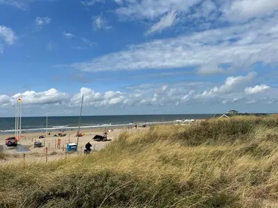 a beach with a lot of people and the ocean at Holiday Home Tapuit 6-2 by Interhome in Noordwijk