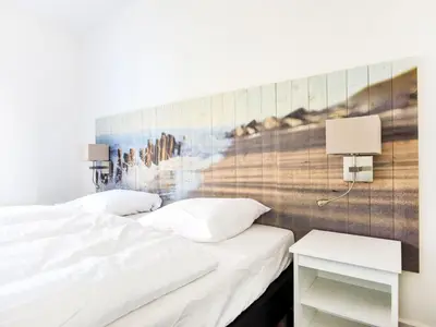a bedroom with two beds and a painting on the wall at Holiday Home Tapuit 6-2 by Interhome in Noordwijk