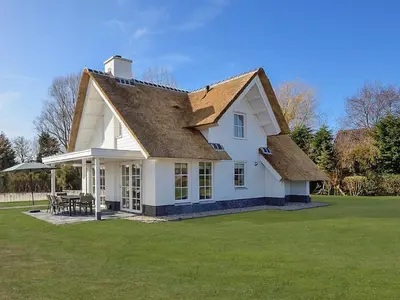 a white house with a roof on a lawn at Holiday Home Tapuit 8-1 by Interhome in Noordwijk
