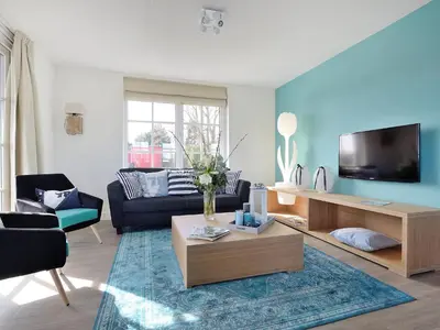 a living room with a couch and a tv at Holiday Home Tapuit 8-1 by Interhome in Noordwijk